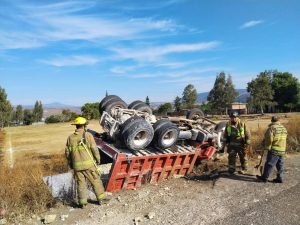 Conductor de un tractocamión resultó lesionado tras perder el control y volcarse